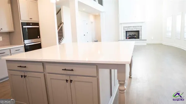 a kitchen with stainless steel appliances granite countertop a sink a stove a refrigerator and white cabinets