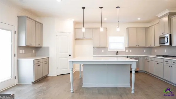 an empty room with wooden floor fireplace and windows