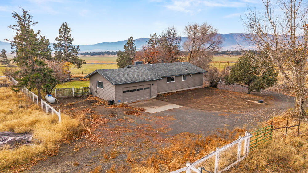 23131 North Poe Valley Road Klamath Falls, OR 97603 - Photo 6 of 45 a yellow house with trees in front of it