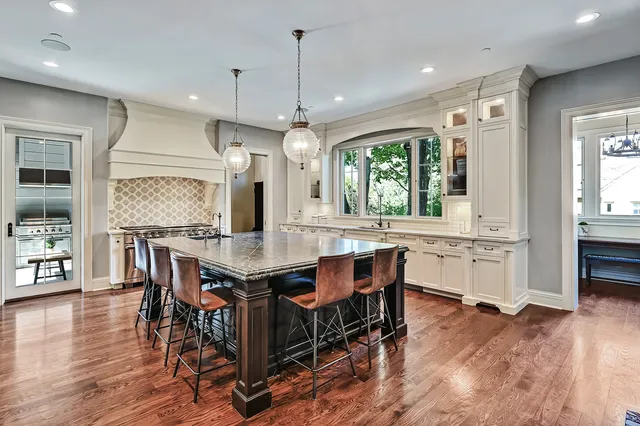 a kitchen with kitchen island granite countertop a sink cabinets and wooden floor