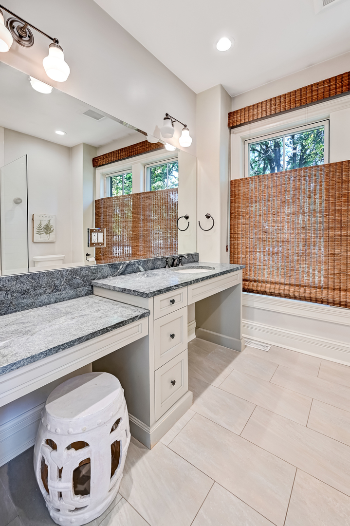 4736 Grand Avenue Western Springs, IL 60558 - Photo 27 of 69 a spacious bathroom with a granite countertop sink and a mirror