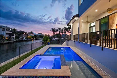 a wooden floor with a swimming pool and sitting area