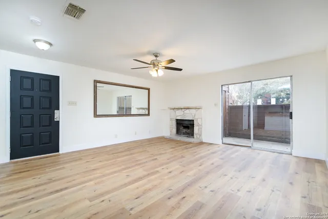 a view of empty room with fireplace and fan