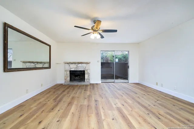 a view of empty room with fireplace and fan