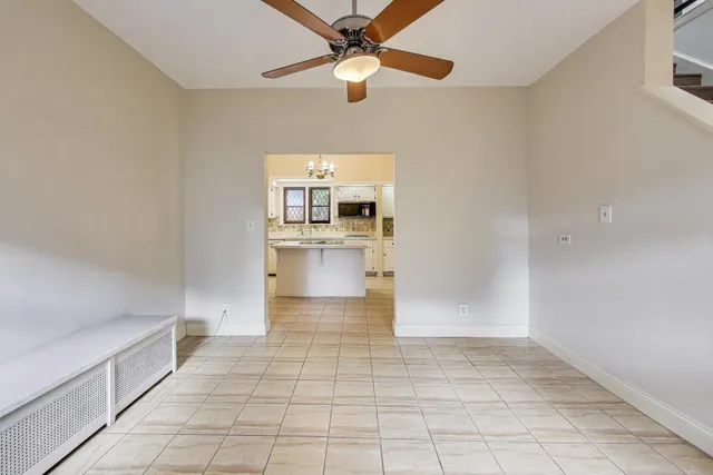a view of a hallway with wooden floor and a bathroom