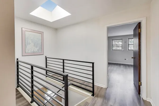 a view of a hallway with wooden floor and staircase