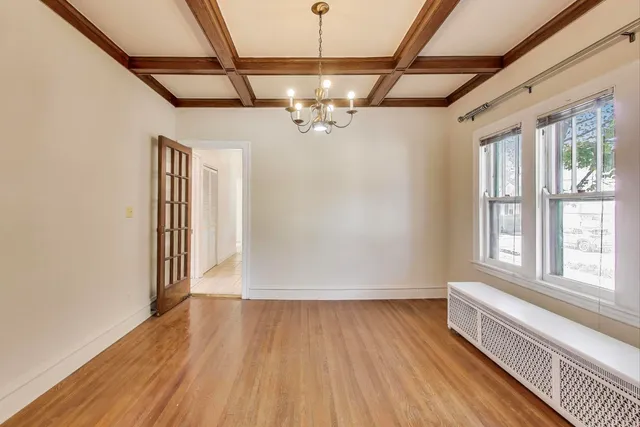 a view of a room with wooden floor a ceiling fan and windows