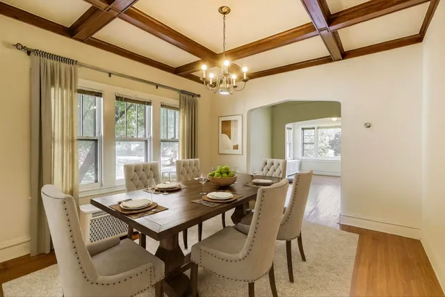 a dining room with furniture a chandelier and wooden floor