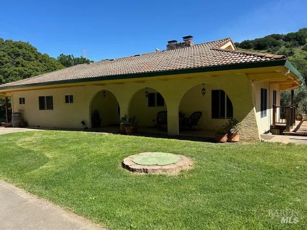 a view of an house with backyard space and sitting area