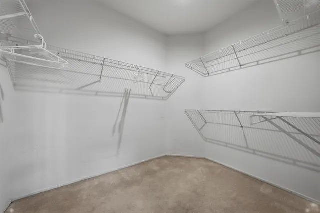 an empty room with windows and ceiling fan