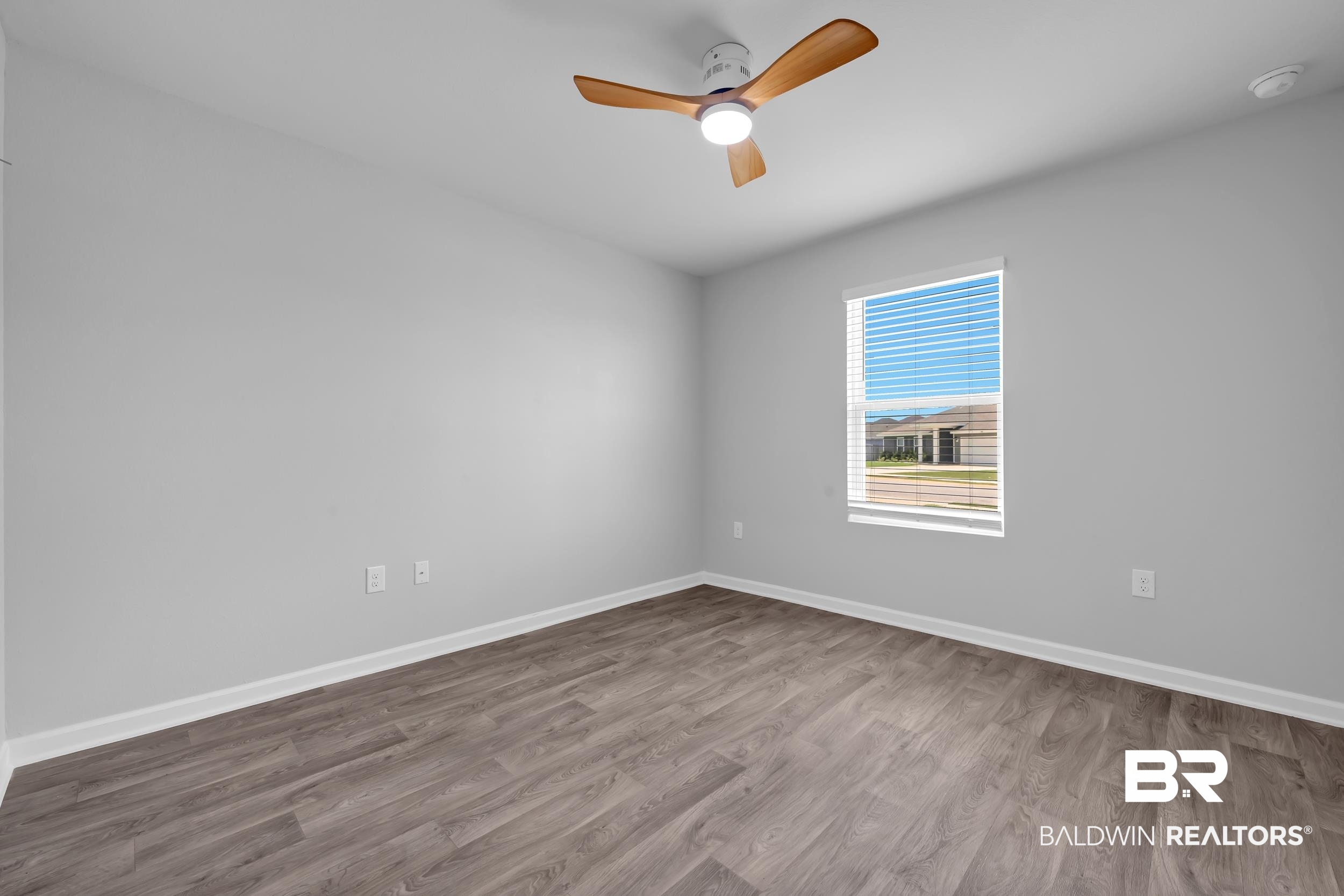 3070 Camino Real Loop Lillian, AL 36549 - Photo 28 of 46 Neutral wall tones, wood-finish flooring, a window with horizontal blinds, white baseboards, and a ceiling fan with integrated lighting