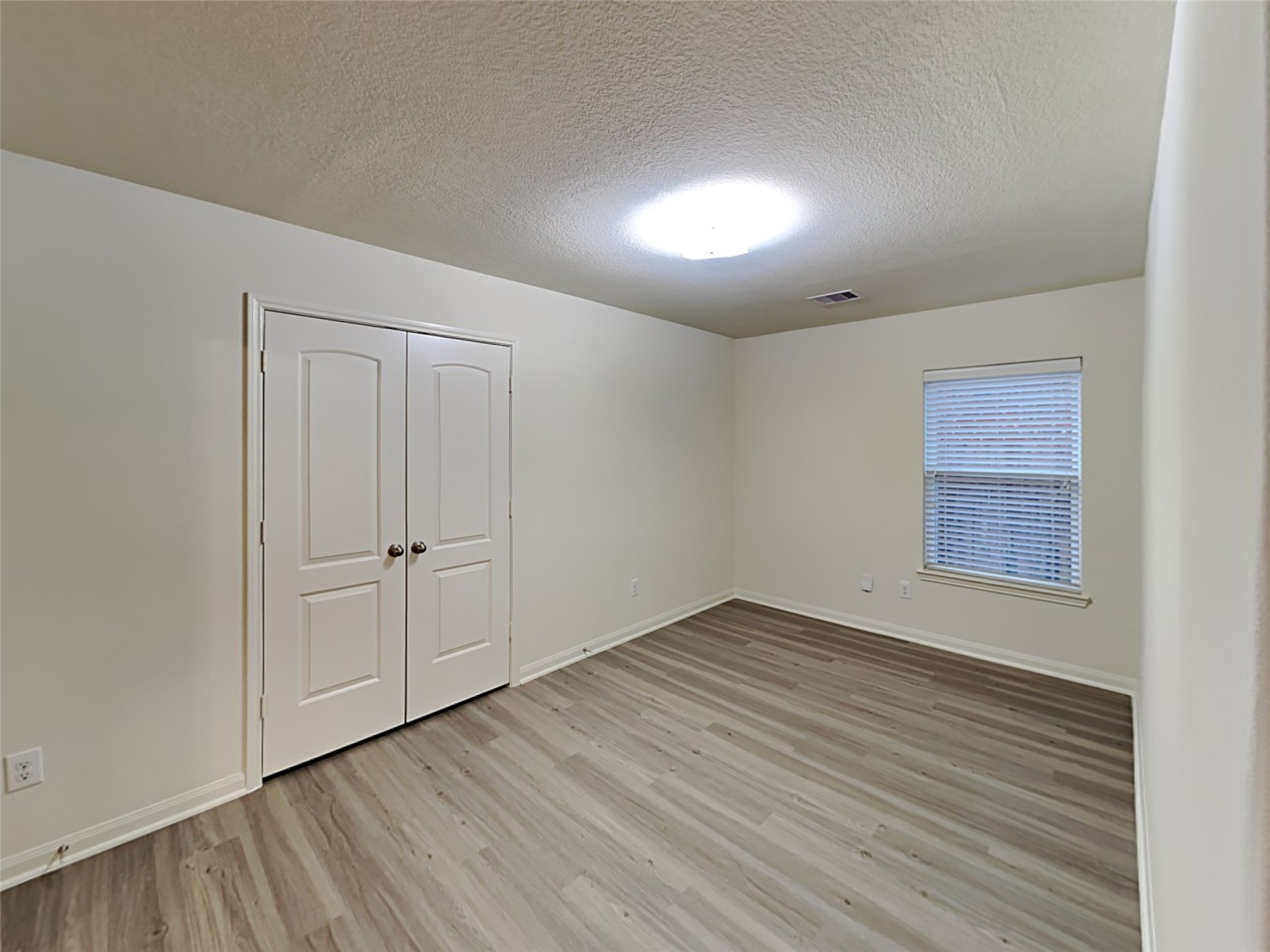 22718 Klingamans Way Hockley, TX 77447 - Photo 9 of 20 a view of an empty room with wooden floor and a window