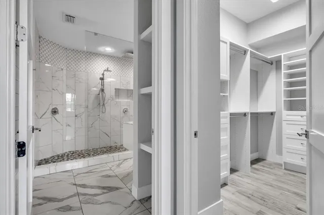 a bathroom with a sink shower and a mirror