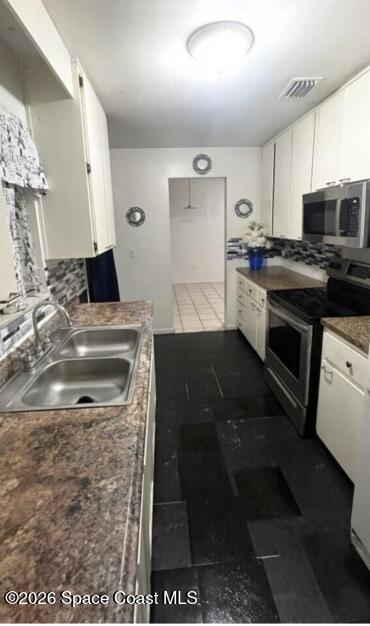 2964 Garden Terrace Northeast Palm Bay, FL 32905 - Photo 2 of 6 a kitchen with stainless steel appliances granite countertop a stove a sink and a microwave