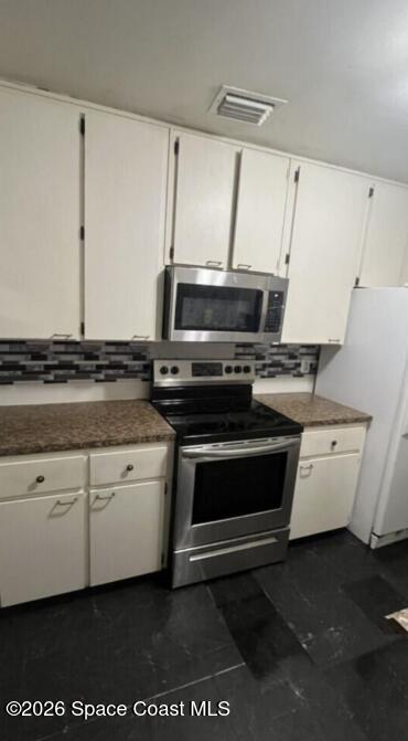 2964 Garden Terrace Northeast Palm Bay, FL 32905 - Photo 4 of 6 a kitchen with a stove and a microwave