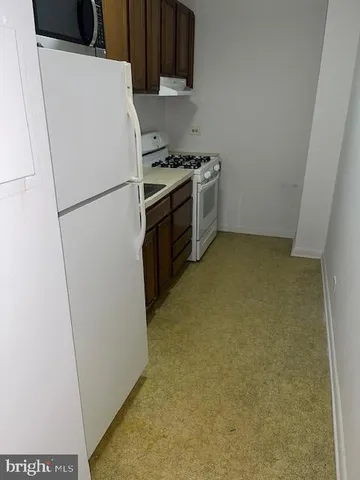 a kitchen with a refrigerator stove and white cabinets