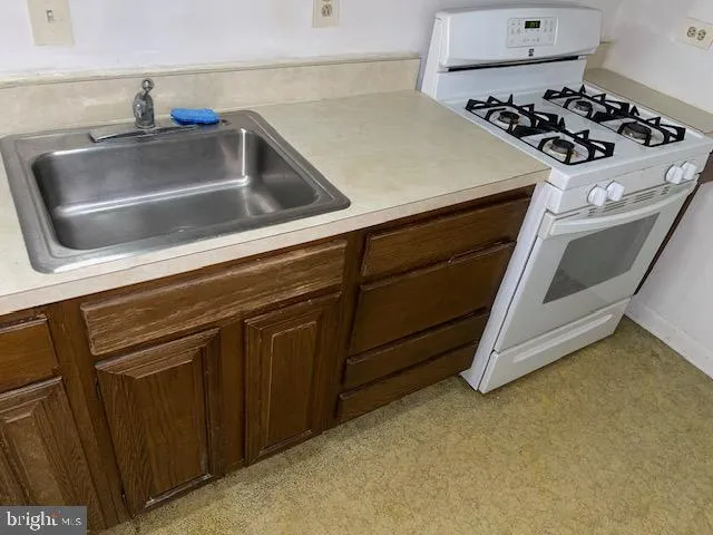 a close view of a sink a stove and cabinets