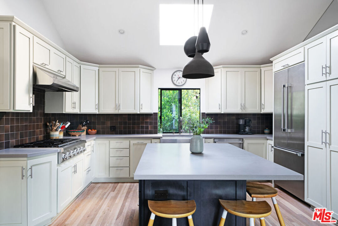 25761 Vista Verde Drive Calabasas, CA 91302 - Photo 8 of 22 a kitchen with stainless steel appliances a center island cabinets and wooden floor