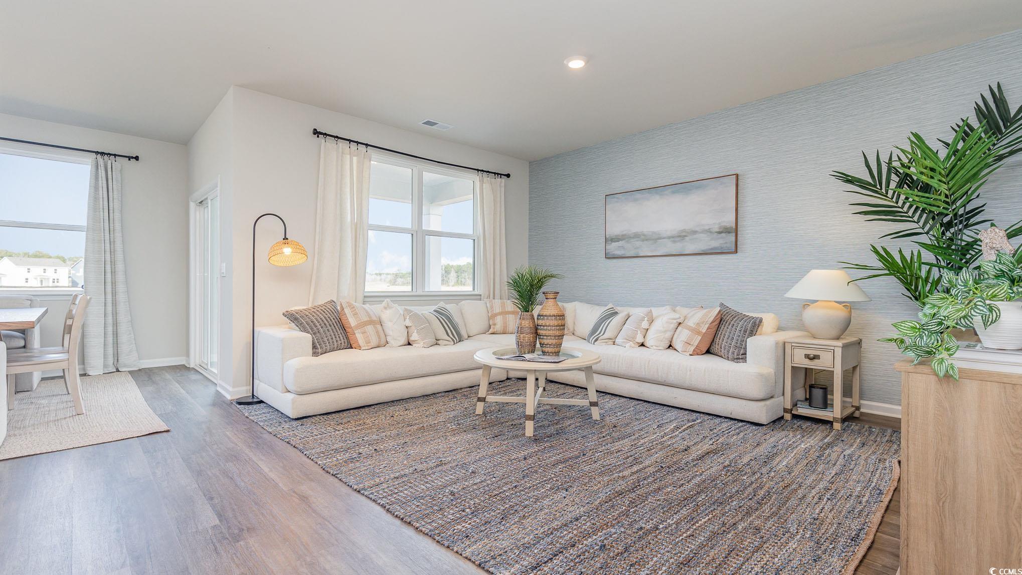 592 Duvall Street Longs, SC 29568 - Photo 10 of 28 Living area with wood finished floors, an accent wall, wallpapered walls, and recessed lighting