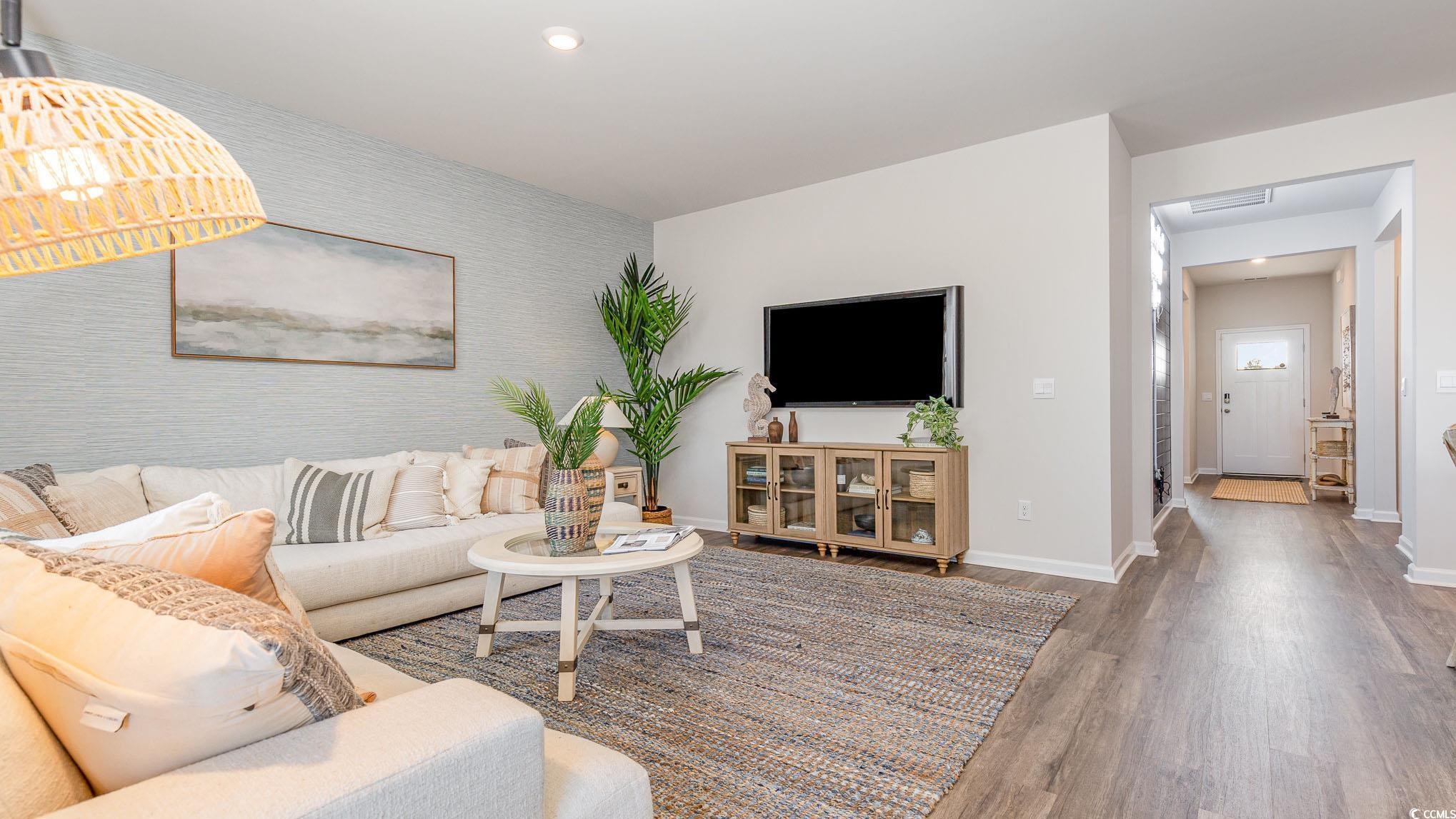 592 Duvall Street Longs, SC 29568 - Photo 12 of 28 Living room featuring wood finished floors and an accent wall