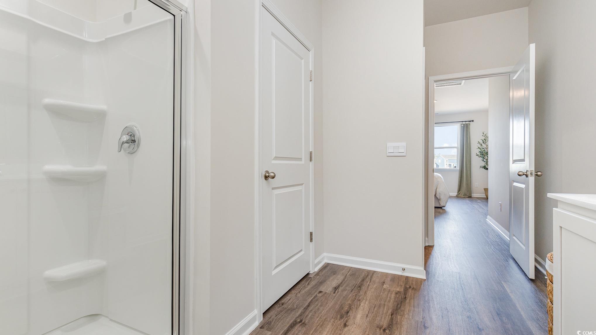 592 Duvall Street Longs, SC 29568 - Photo 18 of 28 Ensuite bathroom featuring dark wood finished floors, a shower stall, and vanity