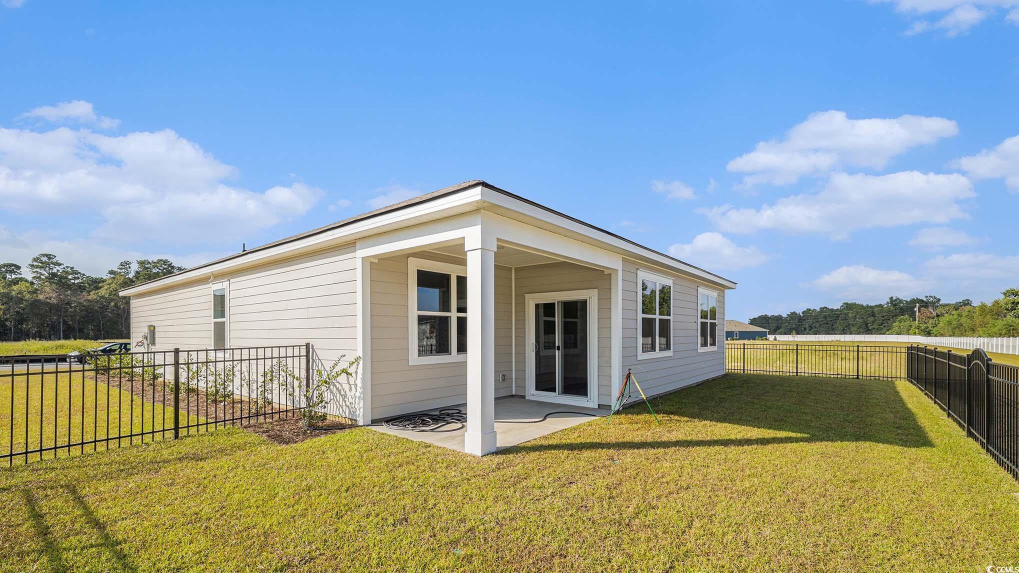 592 Duvall Street Longs, SC 29568 - Photo 2 of 28 Rear view of house with a fenced backyard and a patio
