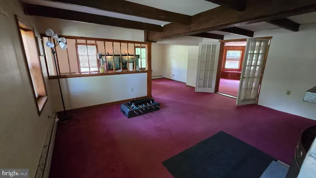 a view of empty room with wooden floor and windows