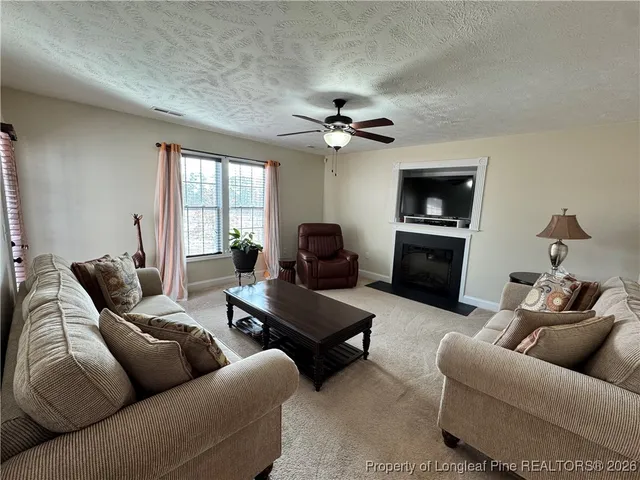 a living room with furniture ceiling fan and a window