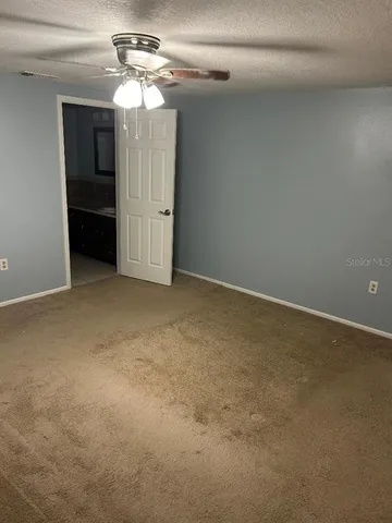 a view of an empty room with a ceiling fan