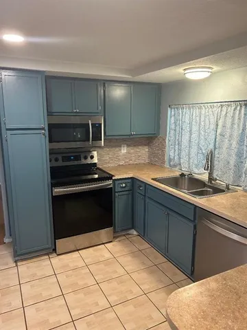 a kitchen with a sink and a refrigerator