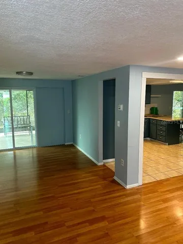 a view of empty room with wooden floor and floor to ceiling window