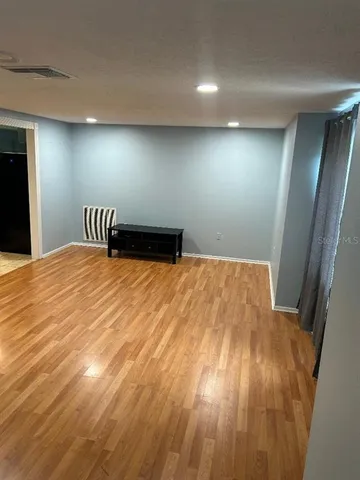 a view of empty room with wooden floor