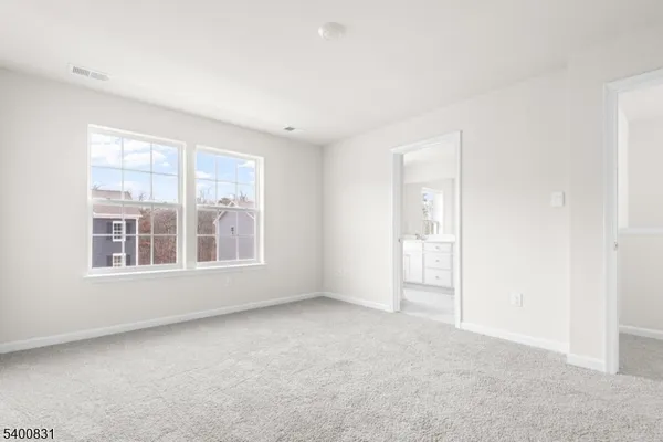 a view of an empty room with a floor to ceiling window and a lake view