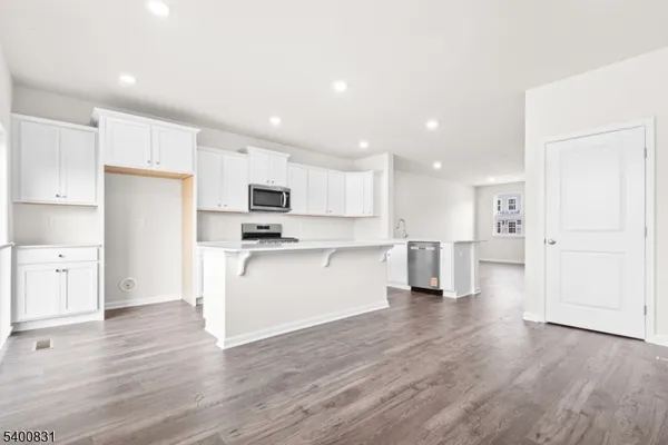 a view of kitchen with granite countertop stainless steel appliances refrigerator sink and cabinets