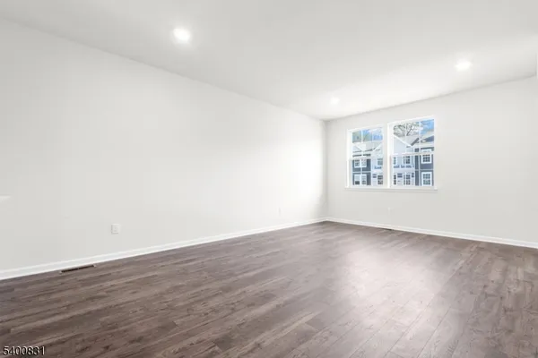 an empty room with wooden floor and window