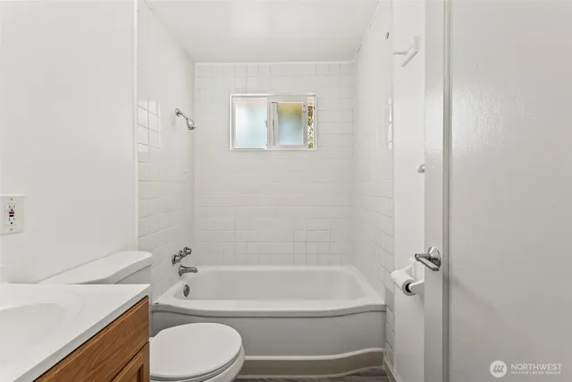 a bathroom with a granite countertop toilet a sink and bathtub