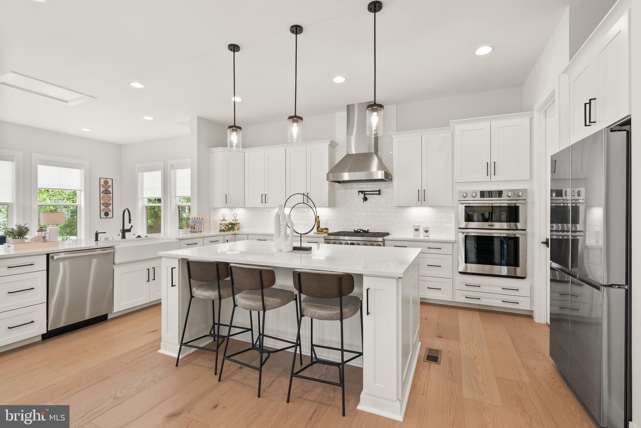 1212 Drake Street Southwest Vienna, VA 22180 - Photo 30 of 84 a large kitchen with stainless steel appliances kitchen island granite countertop a sink a stove a refrigerator and a dining table with wooden floor