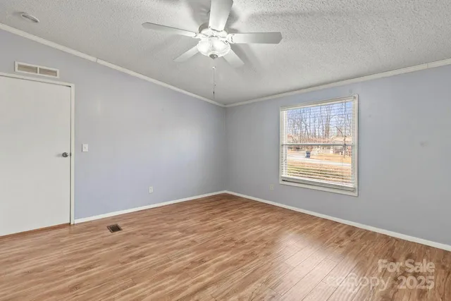 a view of an empty room with a window and a ceiling fan