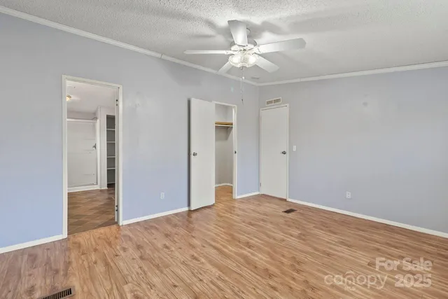 a view of empty room with window and ceiling fan