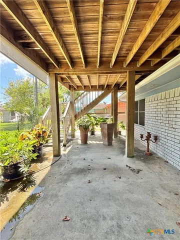 a view of a brick house with a large tree