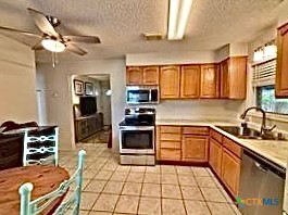 208 Washington Boulevard Port O'Connor, TX 77982 - Photo 17 of 47 a kitchen with stainless steel appliances granite countertop a stove top oven a sink a counter space and cabinets