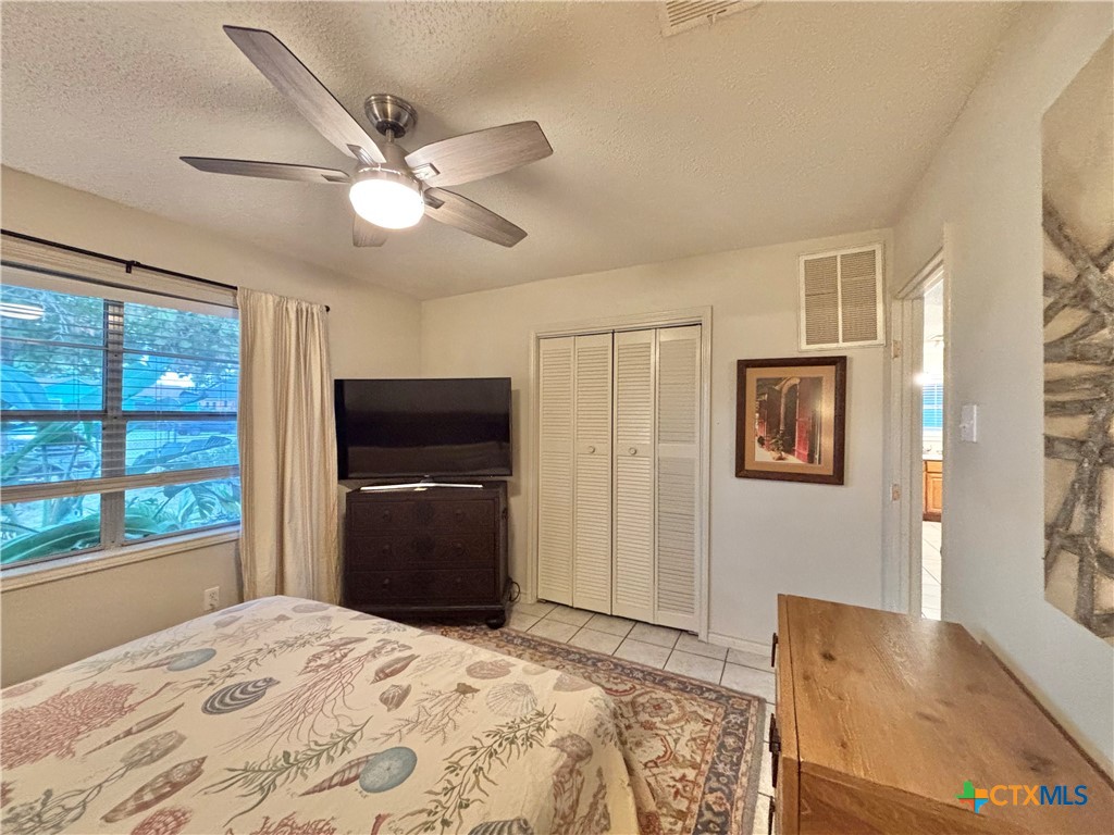 208 Washington Boulevard Port O'Connor, TX 77982 - Photo 23 of 47 a bedroom with a bed and a dresser with wooden floor