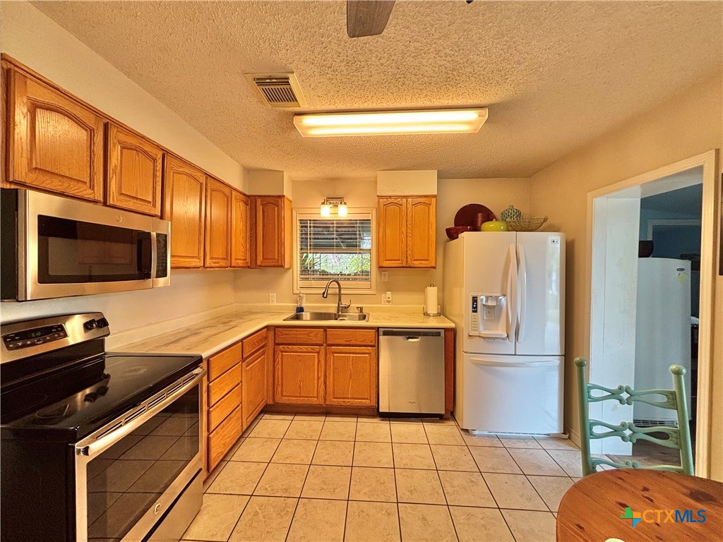 208 Washington Boulevard Port O'Connor, TX 77982 - Photo 6 of 47 a kitchen with stainless steel appliances granite countertop a refrigerator and a stove top oven