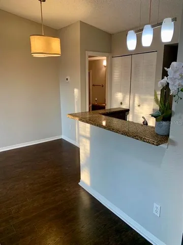 a large kitchen with granite countertop a stove a sink and a wooden floor