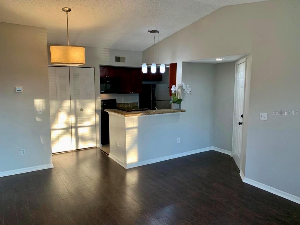 5152 Conroy Road, Unit 35 Orlando, FL 32811 - Photo 8 of 13 a view of a living room with wooden floor and a flat screen tv