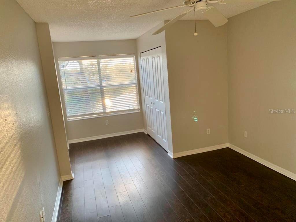 5152 Conroy Road, Unit 35 Orlando, FL 32811 - Photo 10 of 13 an empty room with wooden floor and windows