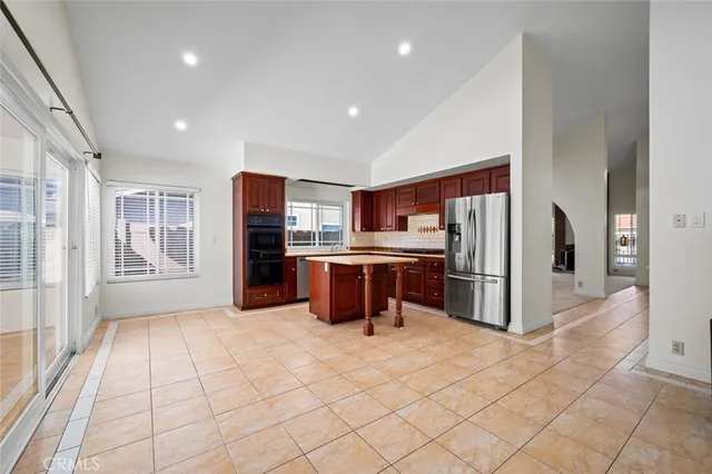 a kitchen with stainless steel appliances granite countertop a refrigerator a stove a sink and dishwasher