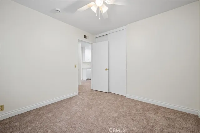 an empty room with a window and a fan