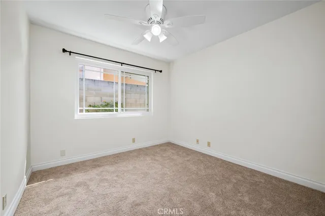 an empty room with a ceiling fan and a window