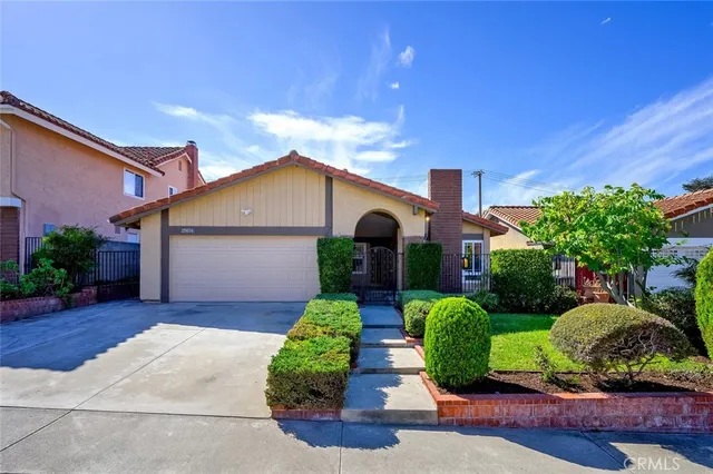 a front view of a house with a yard and potted plants
